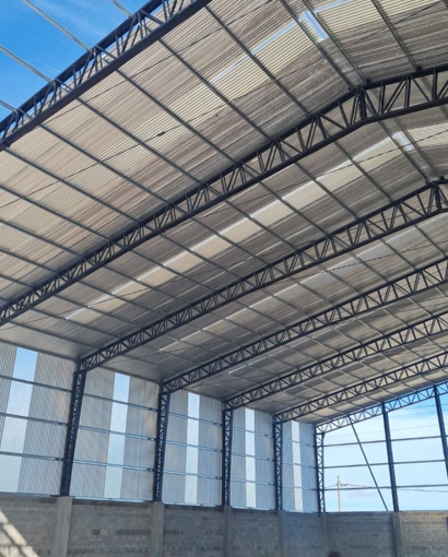 Galpón industrial con estructura metálica y piso de hormigón armado.
